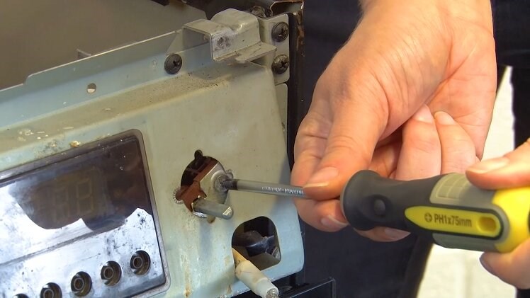 Use a Phillips screwdriver to partially unscrew one of the screws that hold the selector switch in place