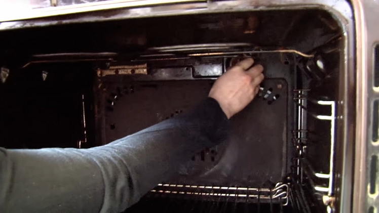 Unscrewing The Lamp Cover And Bulb Inside The Back Of The Oven