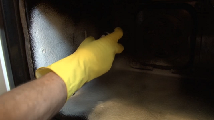 Spraying The Interior Of The Oven With The Oven Cleaner Spray