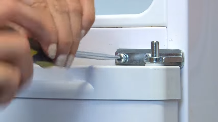 Removing The Screws From The Middle Hinge With A Flat Blade Screwdriver