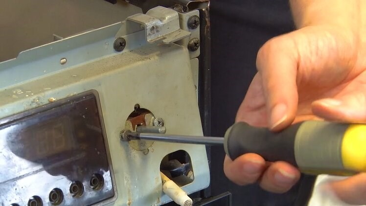 Use a Phillips screwdriver to fully unscrew one of the screws that hold the selector switch in place