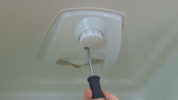 Removing The Screw Holding The Thermostat Cover In Place Using A Phillips Screwdriver