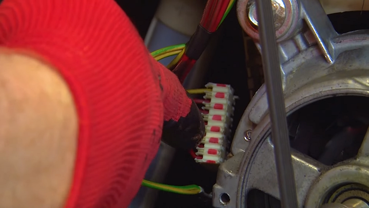 Plug the motor plug and the earth wire back into their slots to the left of the motor.