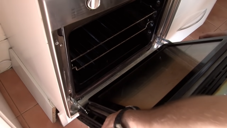 Sliding The Oven Door Into Place With The Hinges Going Back Into Their Slots