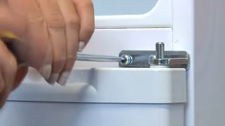 Removing The Screw Holding The Middle Hinge With A Flat Blade Screwdriver