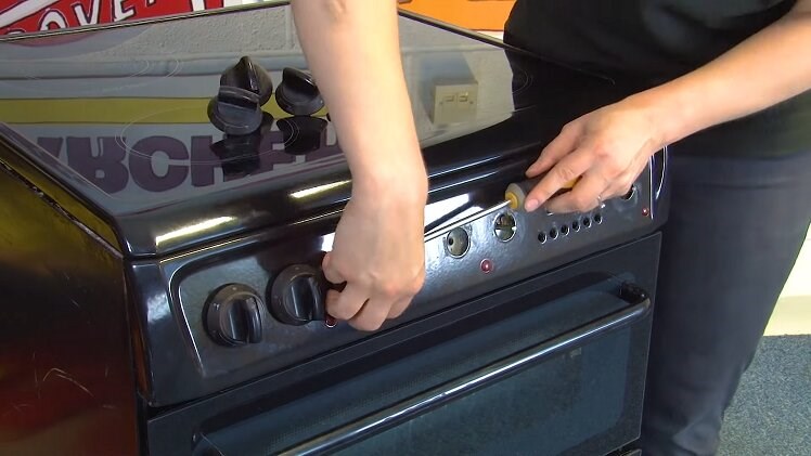 Use a flathead screwdriver to remove all of the control knobs and buttons from the control panel