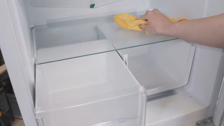 Wiping Clean The Shelves, Drawers And Interior Surfaces Of The Fridge Using An Anti-Bacterial Spray And A Clean Cloth
