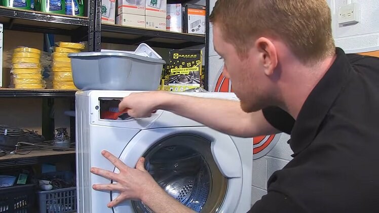 Using A Long Handled Brush To Scrub The Inside Of The Washing Machine Detergent Drawer Housing