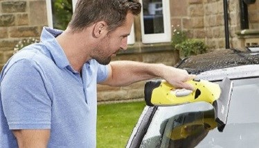 Man cleaning car with window vacuum