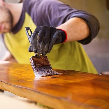 Man varnishing wood