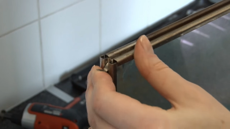Positioning The Two Sheets Of Glass Together And Locking The Frame Back Around Them