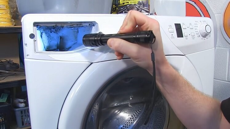 Inspecting The Inside Of The Washing Machine Detergent Drawer With A Torch