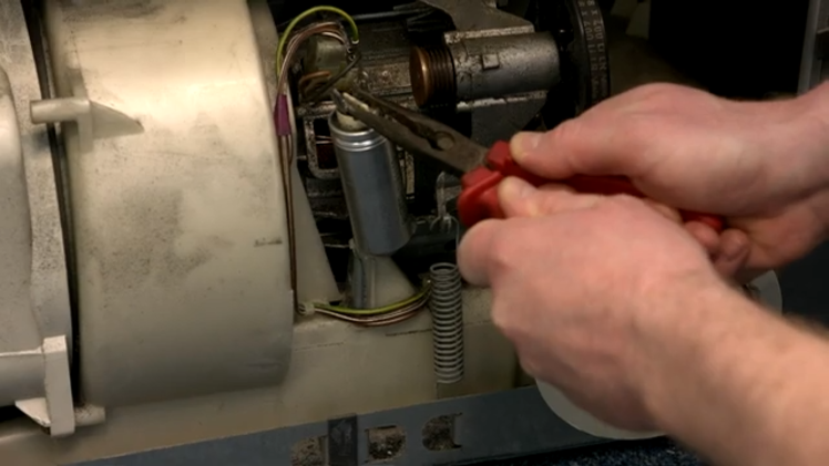 Dispensing Any Charge In The Motor Capacitor By Using A Pair Of Insulated Pliers And Pressing The Metal Prongs Across The Electric Terminals