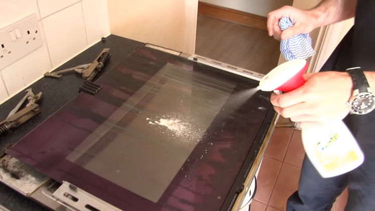 Giving The Oven Door A Clean With Oven Cleaner And A Cloth