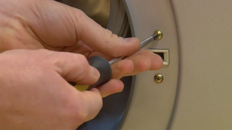 Use a Phillips screwdriver to unscrew the two screws that hold the door lock to the inside of the door frame