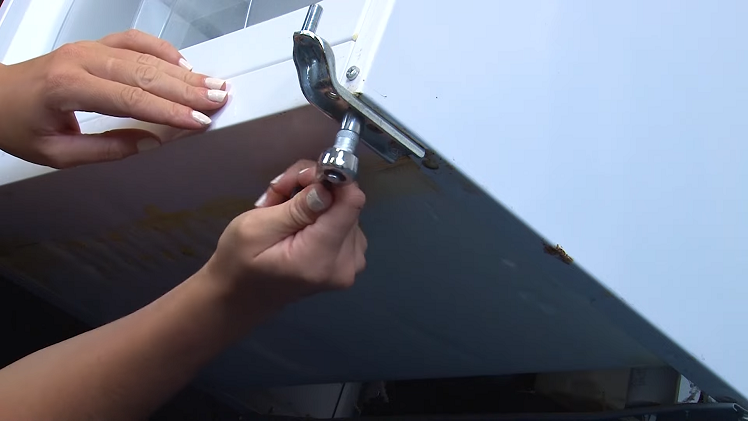 Removing The Two Head Bolts From Beneath The Bottom Hinge Using A Ratchet