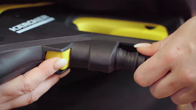 Press down the yellow hose release button on the pressure washer hand gun