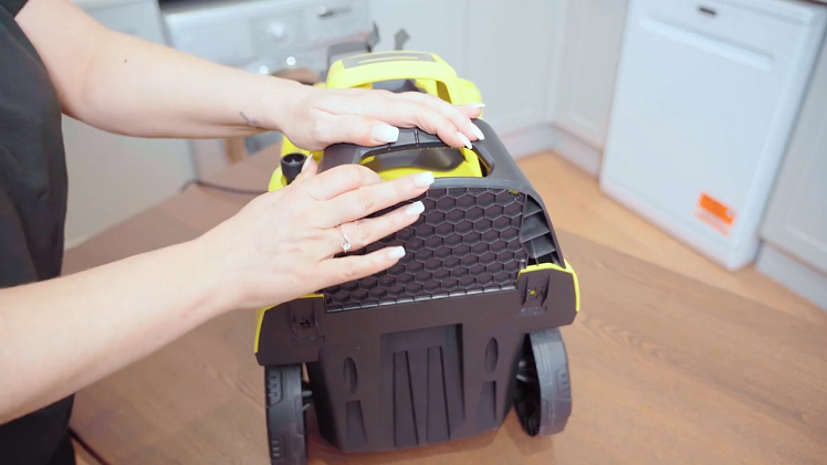 Slot the tool carrier into place on the front of the pressure washer at the bottom.