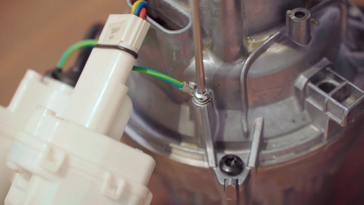 Use your Torx T20 screwdriver to unscrew the earth screw (indicated below) that connects the main earth wire to the motor.