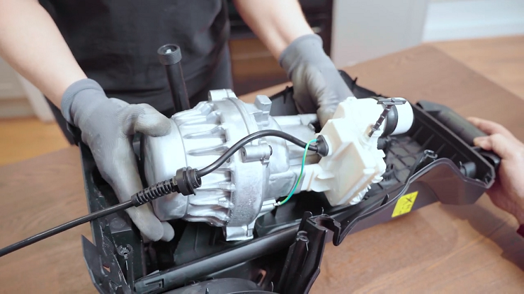 Start by fitting the motor back into the pressure washer using a second person to help you do this.