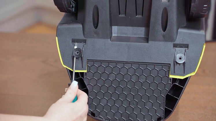 Wedge your screwdriver blade underneath and loosen the tool carrier lugs enough to grip the circular end with your pin nose pliers.