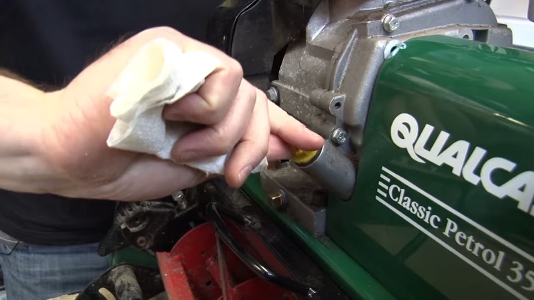 Screwing The Dipstick Back Into The Back Of The Petrol Lawnmower