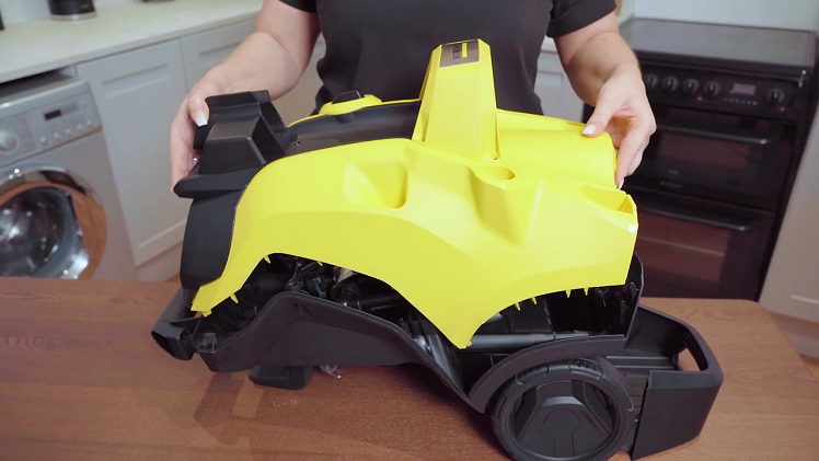 Holding the casing on either side, carefully wiggle it free of the water inlet valve inside, and lift it up a little.