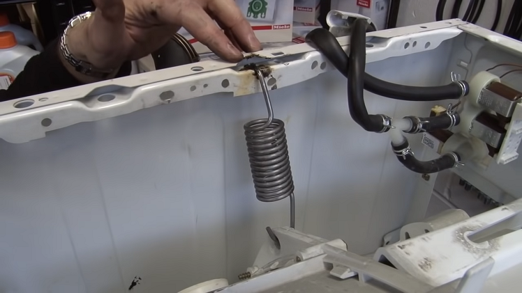 The last things holding the tub in place are the springs. Simply unhook these by hand.