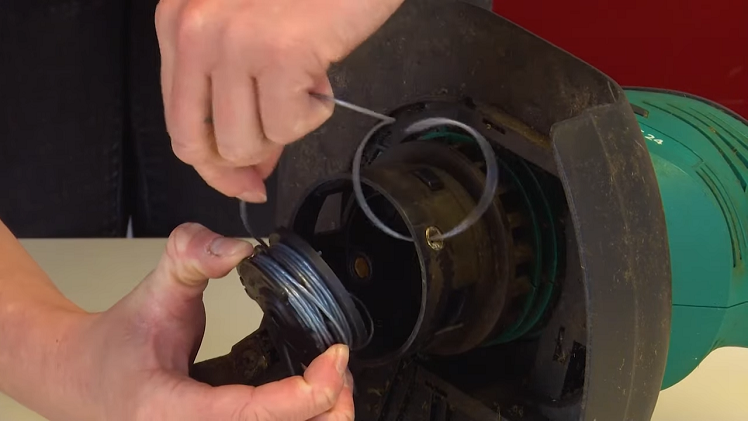 Pulling The Spool Off Of The Spindle It Sits On And Gently Feeding The Trimmer Line Through The Outlet Holes