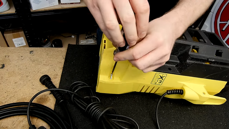 Unscrewing The Seven Screws That Hold The Two Halves Of The Pressure Washer's Body Together Using A Torx Screwdriver