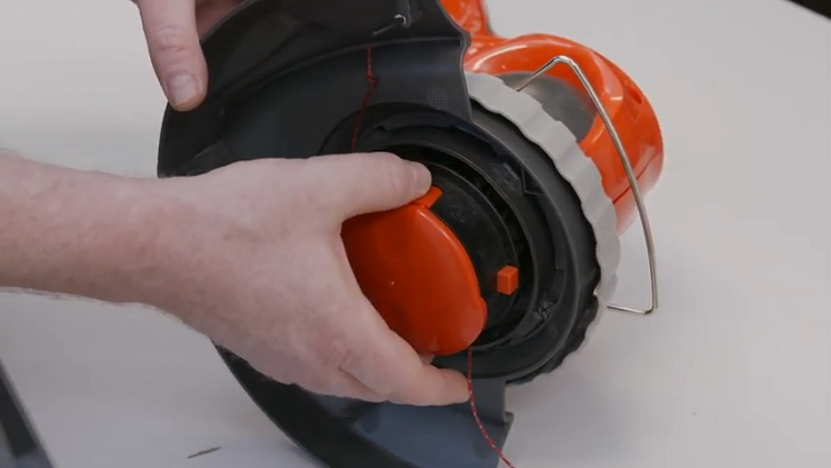 Removing The Spool By Pushing In The Tabs On Either Side And Pulling Out