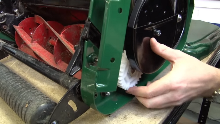 Checking The Three Nylon Gears Alongside The Belts On The Petrol Lawnmower For Any Damage