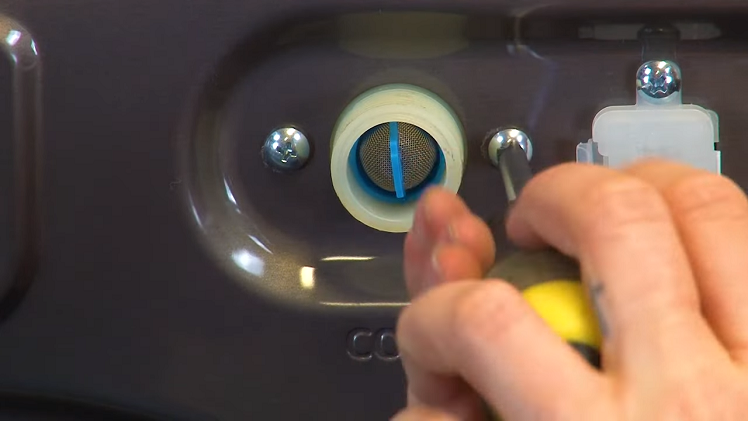Using the screws you removed earlier, screw the valve back into place on the back panel of the washing machine to secure it.