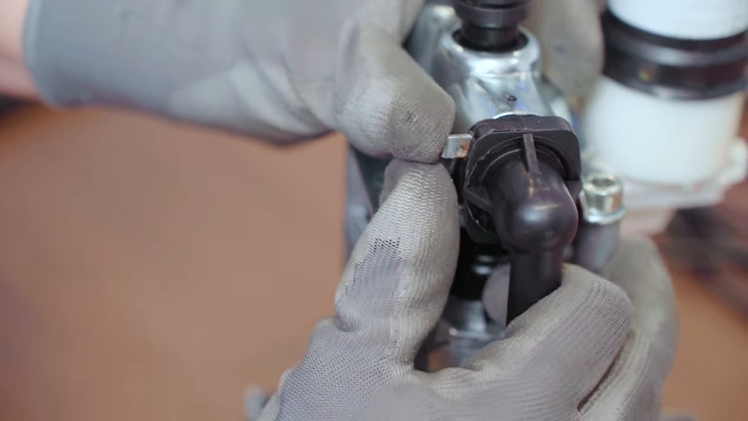 Secure the pipe by pushing the metal circlip back into place.