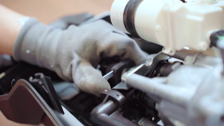 Slot the metal clip back into place on the pump housing above the motor.