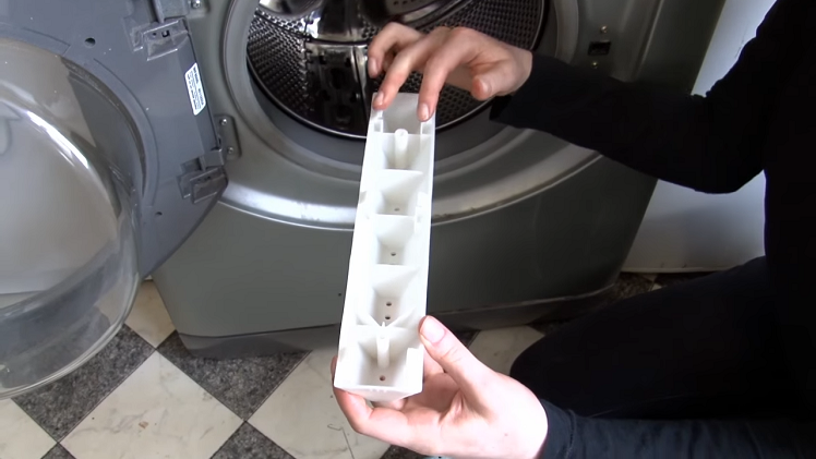 Line up the clips on the bottom of the paddle with the holes inside the washing machine drum.