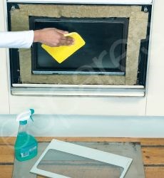 Cleaning The Oven Door With Cleaning Spray And A Cloth