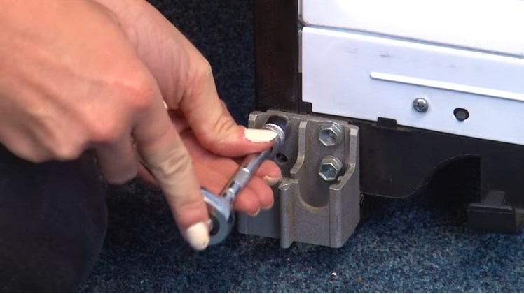 Removing The Freezer Lower Hinge Bracket By Removing The Three Ten Millimeter Bolts Using A Ratchet