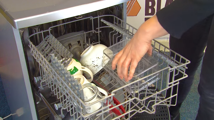 A Plastic Container Facing Downward On The Dishwasher Upper Basket Shelf