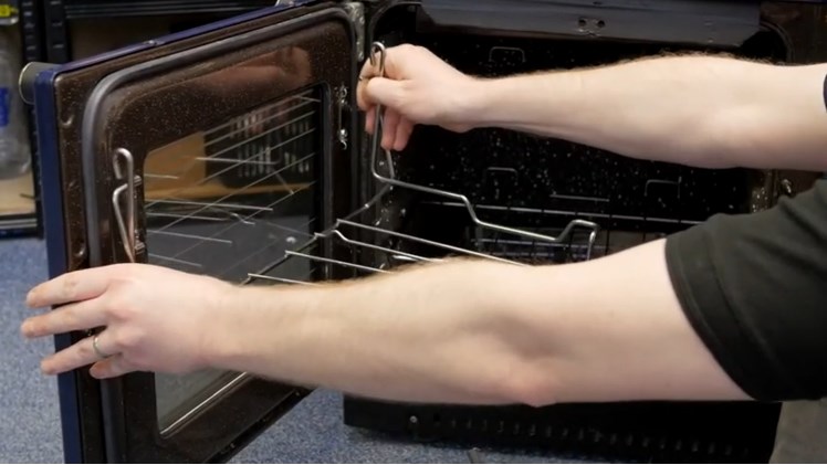 Unhooking The Oven Rack By Gently Lifting It Off The Catches