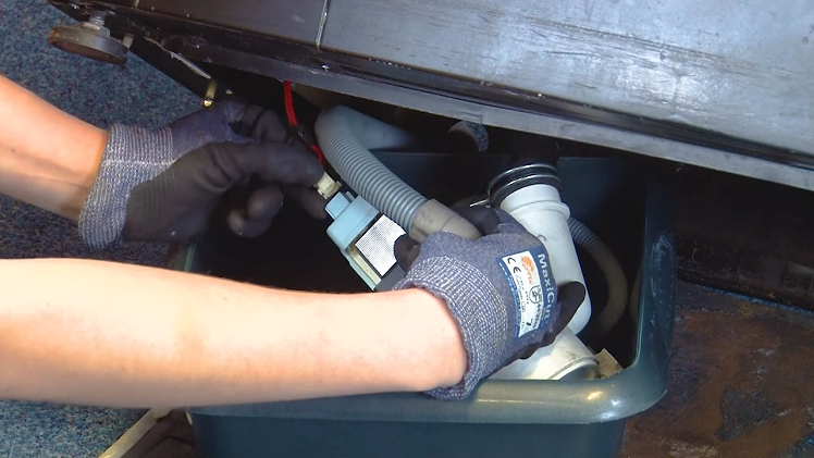 Put on a pair of safety gloves to protect your hands and unplug the electrical plug connection from the back of the drain pump.