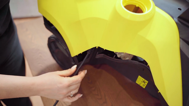 Make sure that the two black tabs at the bottom of the pressure washer go outside the casing and align the mains cable with the indent on the side of the pressure washer.