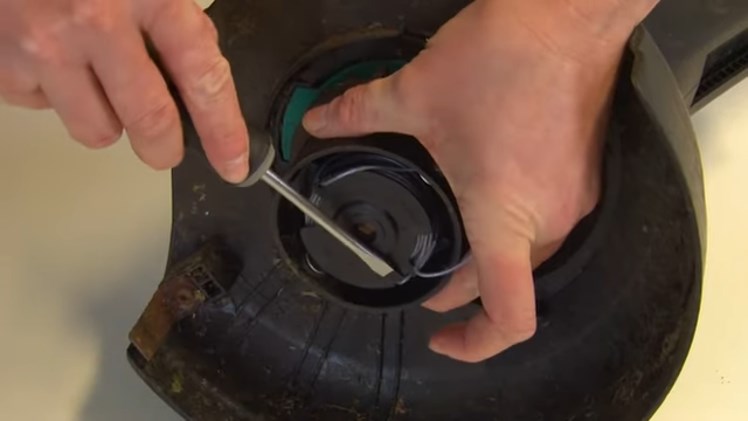 Unhooking The Line From The Cleats Using A Flathead Screwdriver