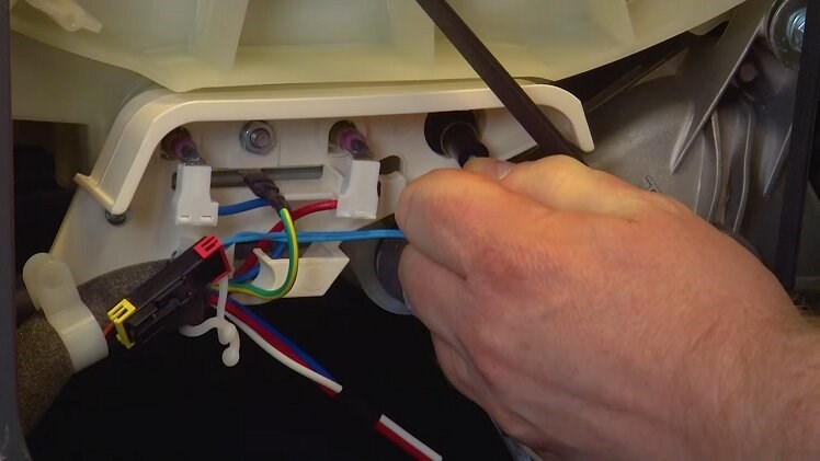 Push the thermostat into place in its slot beneath the drum and next to the heating element