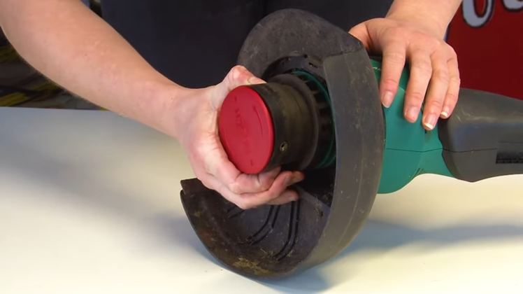 Pressing In The Two Tabs On Either Side Of The Trimmer Head And Gently Pulling The Spool Cover Upwards And Away From The Spool