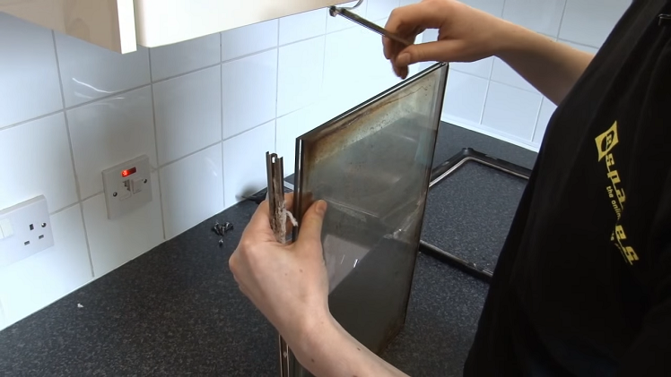 Unhooking The Metal Frame At The Corners To Open The Frame To Separate The Glass