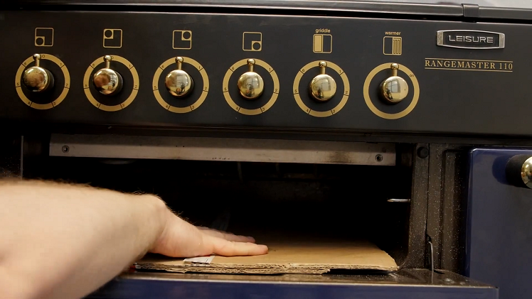 Laying A Piece Of Cardboard Under The Grill To Protect Hands And Arms
