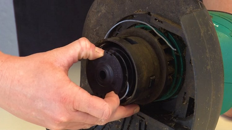 Gently Pulling The Spool Off The Spindle That It Sits On