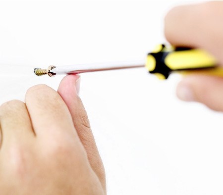 Using A Screwdriver To Screw A Nail Into A Wall