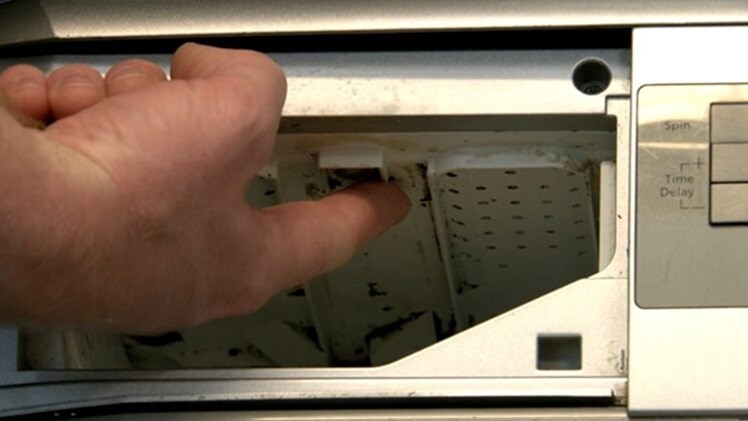 The small holes which are water jets on the inside roof of the washing machine dispenser
